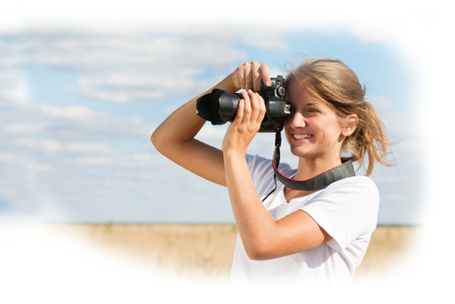 Girl holding a camera in a field