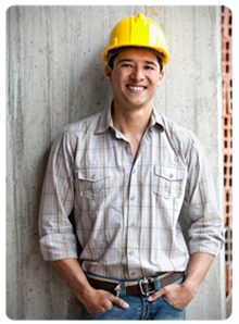 Smiling construction worker leaning against wall